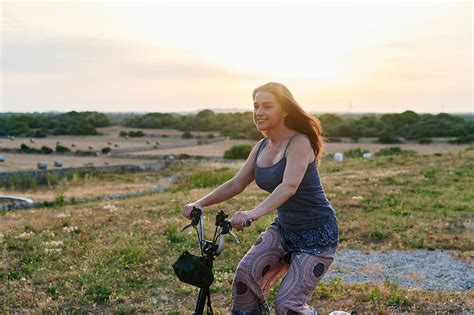 Smiling Woman Riding A Bike In The Countryside By Stocksy Contributor