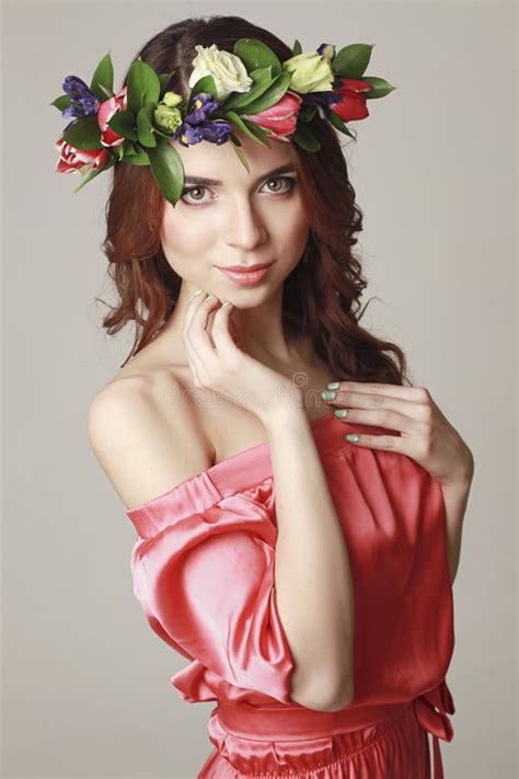 gentle romantic appearance of the girl with a wreath of roses on her head and a pink dress