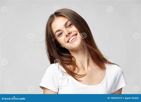 Woman Tilted Her Head To The Side And Smiling On A Light Background