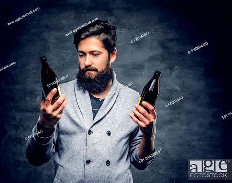 Full Throttle Bearded Male Holds Two Craft Beer Bottles Stock Photo