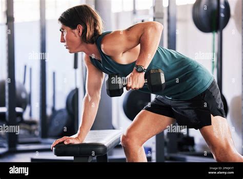 One Fit Young Caucasian Man Doing Single Arm Bent Over Rows On A Bench