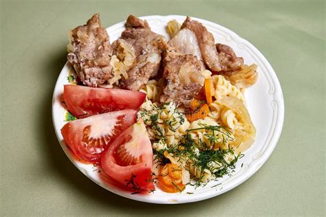 Cooking Grilled Meat On A Plate With Garnish And Tomatoes Stock Photo