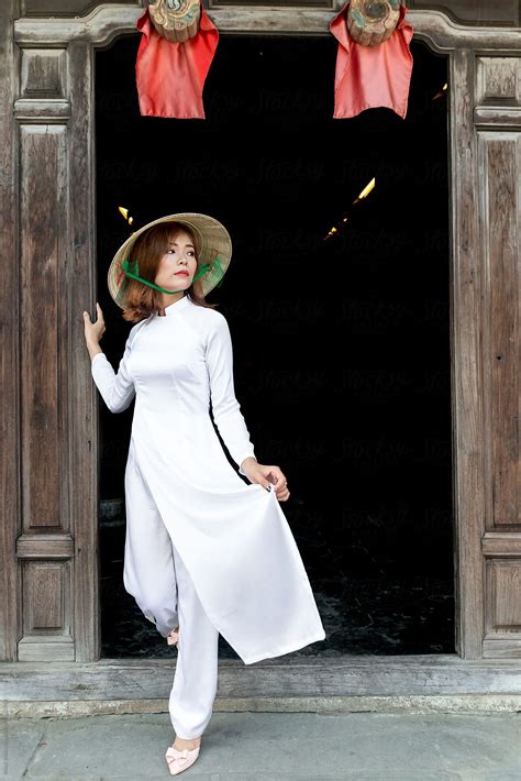 Vietnamese Woman In White Ao Dai Traditional Costume And Conical Hat By Stocksy Contributor