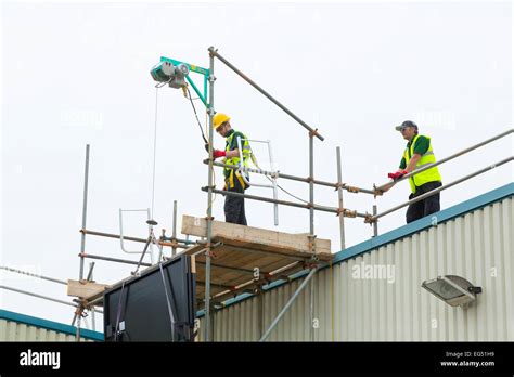 Workers Using An Electric Hoist On A Construction Site Stock Photo Alamy