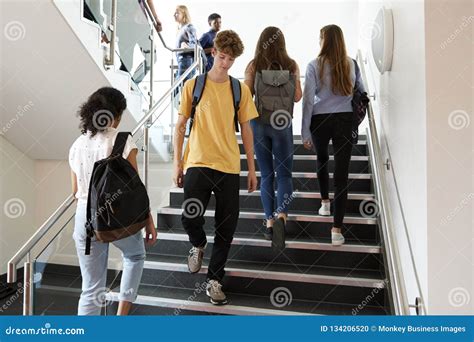 High School Students Walking On Stairs Between Lessons In Busy College