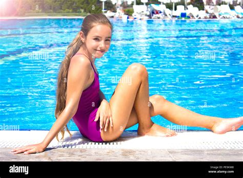 Schönes Junges Mädchen In Lila Badeanzug Am Pool Sitzen Und Lächeln Für