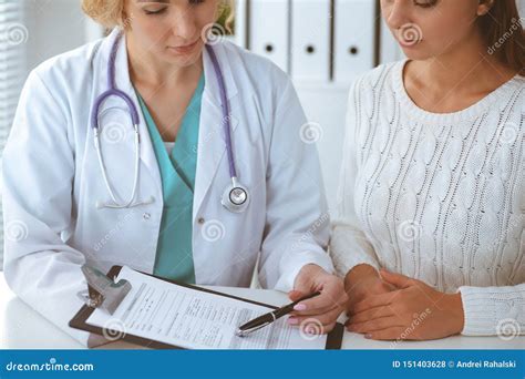 Happy Blonde Female Doctor And Patient Discussing Medical Examination