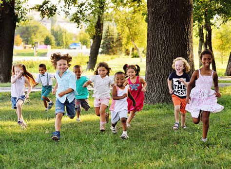A Group Of Preschoolers Running On The Grass In The Park Yellowstone
