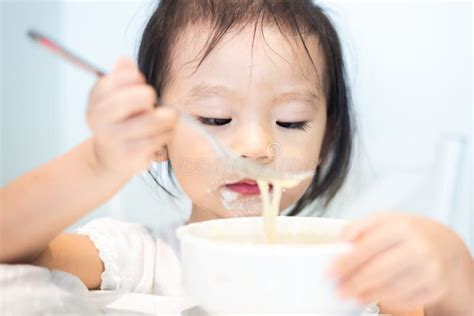 Little Baby Child Eating Noodle And Enjoy Breakfast By Herself Stock