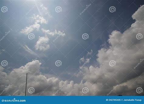 Cumulus Clouds With Tv Antenna Against A Clear Blue Sky Background In