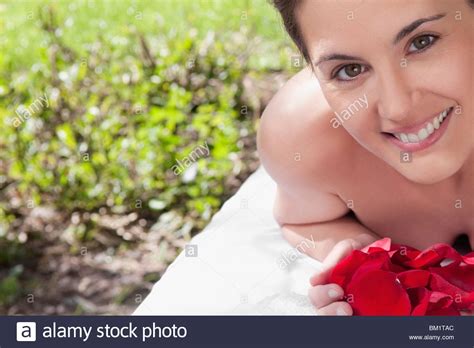 Portrait Of A Woman Lying On A Massage Table Holding Rose Petals Stock