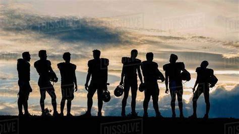 Silhouette Of Group Of Young American Football Players Standing In Row