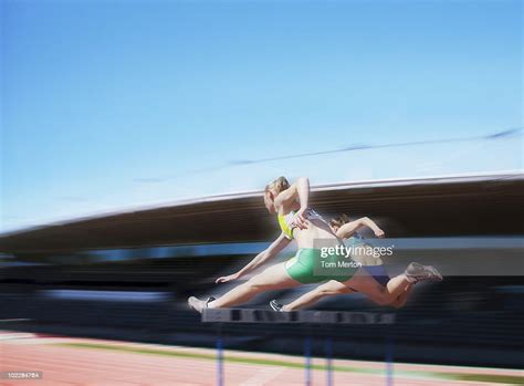 Runners Jumping Over Hurdles High Res Stock Photo Getty Images