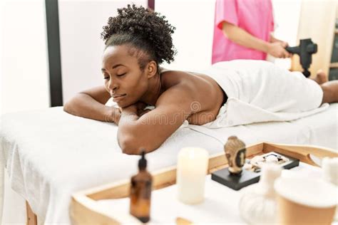 African American Woman Lying On Table Having Legs Massage With