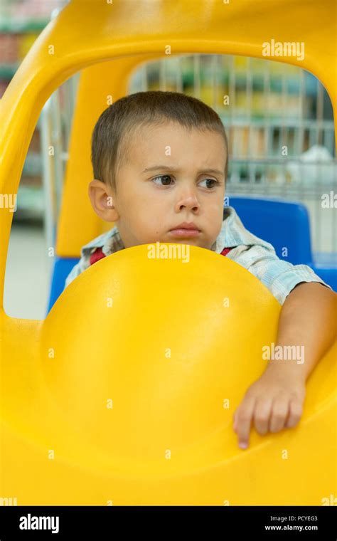 Cute Sad Little 2 Year Old Baby Boy Child In The Little Toy Car Trolley
