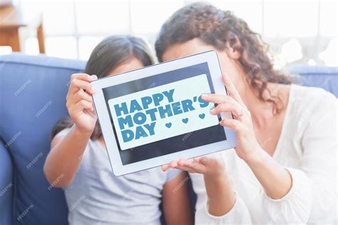 premium photo mothers day greeting against happy mother and daughter sitting on the couch and