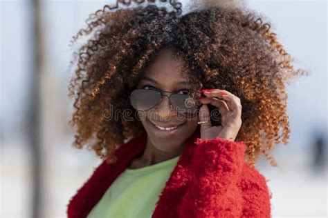 Front View Of A Young Beautiful Curly Woman Standing On Path Smiling While Looking Camera In