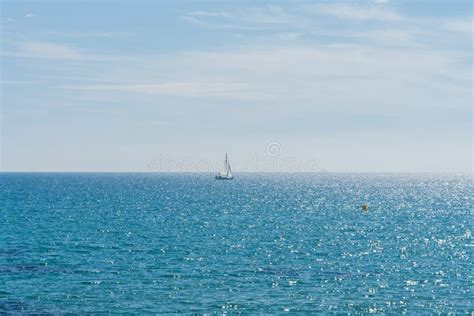 Seascape With Sailboat On The Horizon At The Mediterranean Sea In Spain