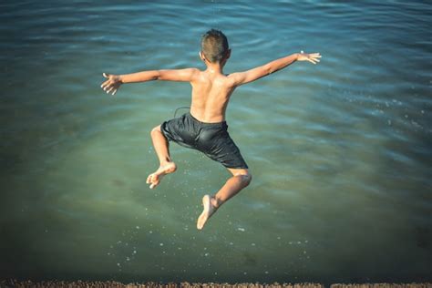 Free Photo Active Boys Jumping From Logs Into Water