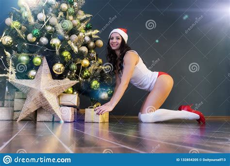 Gelukkige Vrouw Met T Onder Kerstmisboom Het Jonge Sexy Mooie Meisje In Lingerie En Santa