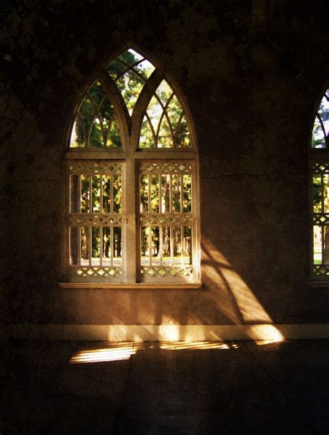 The Sunlight Is Shining Through Two Windows In An Old Building With Stone Walls And Stained Glass
