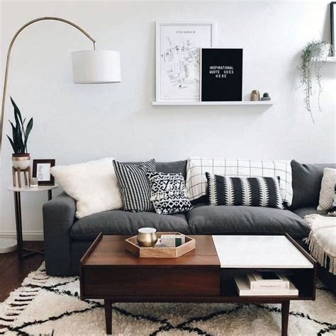 The walnut mantel and warm wood floors bring out the brown undertones in the gray paint, while deep charcoal chairs and furniture are done in light neutrals. Suitable dark grey couch living room decor that look ...