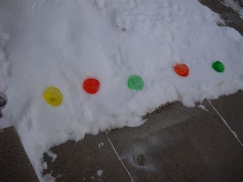 Frozen Water Ballons With Food Coloring Put Out In The Snow And They Look Like Large Marbels
