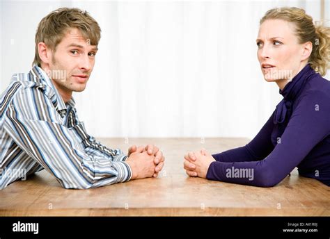 A Couple Sitting Opposite Each Other At A Table Stock Photo Alamy
