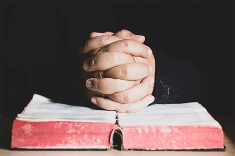 Premium Photo Hands Folded In Prayer On A Holy Bible In Church