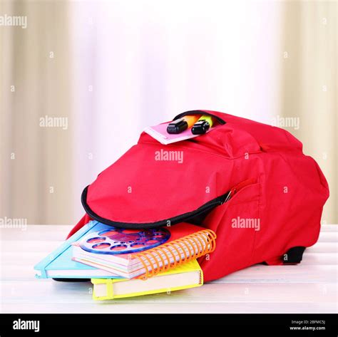 Red Bag With School Equipment On Wooden Table In Classroom Stock Photo