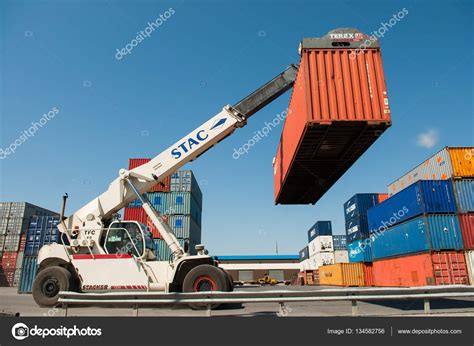 Forklift Truck Lifting Cargo Container In Shipping Yard Or Dock Yard