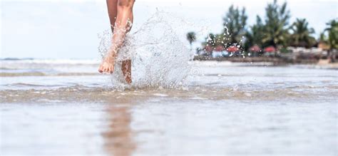 Beautiful Female Legs On The Beach With Water Splashing Stock Image