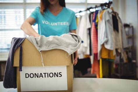 Free Photo Female Volunteer Holding Clothes In Donation Box