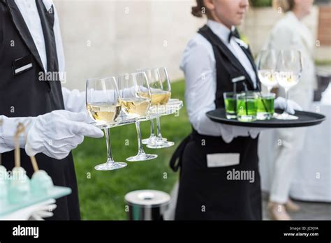 Midsection Of Professional Waiters In Uniform Serving Wine And Snacks