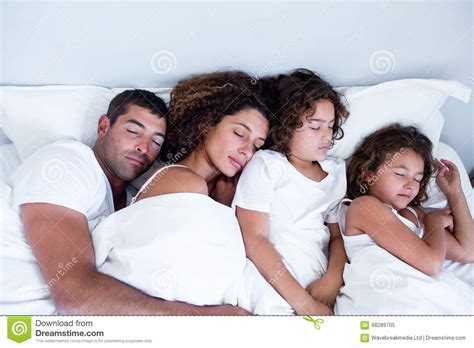 Familia Que Duerme Junto En Cama Imagen De Archivo Imagen De