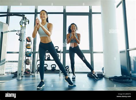 Two Young Women Exercising In Gym Doing Aerobic Workout Stock Photo