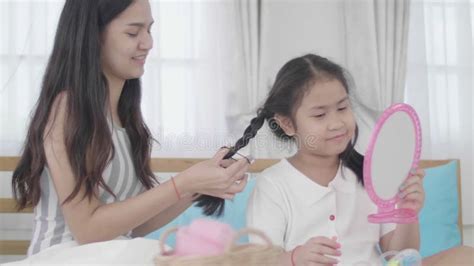 mother and daughter doing your makeup sitting on the bed in the bedroom stock video video of