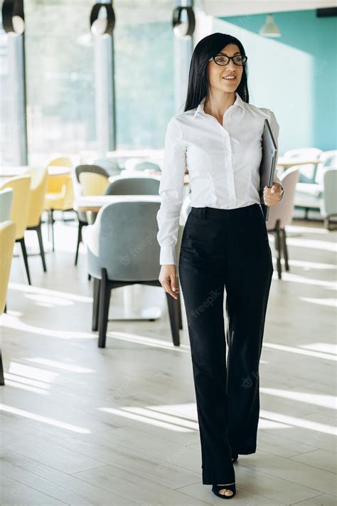 Premium Photo Attractive Business Woman In Formal Wear Standing In Office And Holding Laptop