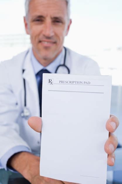 Premium Photo Portrait Of A Male Doctor Showing A Blank Prescription