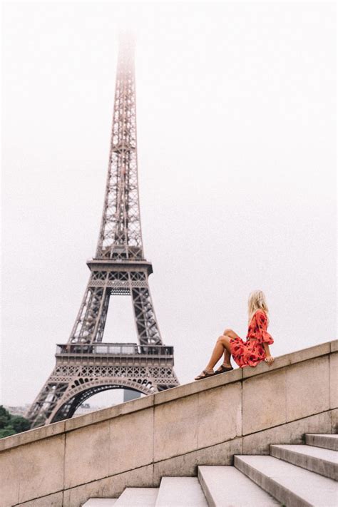 A Woman Sitting On Steps In Front Of The Eiffel Tower