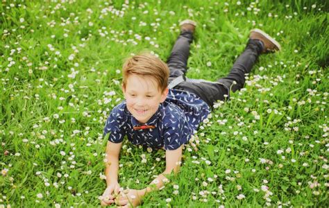 Smiling Boy Lying On Grass Cute Kid Child Enjoying On Field Flower