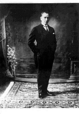 An Old Black And White Photo Of A Man In A Suit Standing On A Rug