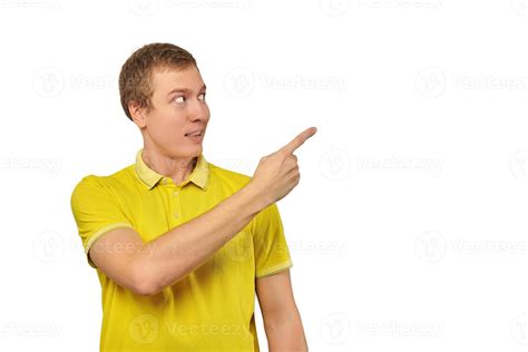 Surprised Guy With Funny Face In Bright Yellow T Shirt Pointing Finger