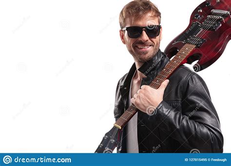 Smiling Man Holding Electric Guitar On Shoulder Looks To Side Stock