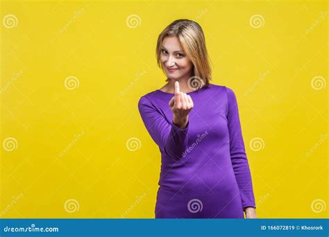 come here portrait of attractive woman making beckoning gesture isolated on yellow background