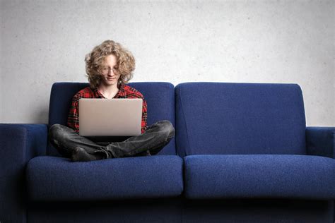 mujer en camisa de manga larga sentada en el sofá azul · fotos de stock gratuitas