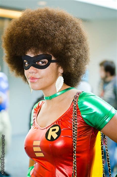 A Woman With An Afro Wearing A Red And Green Costume Is Posing For The Camera