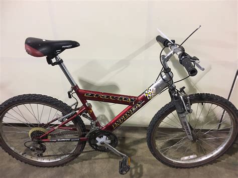 2 Bikes Grey Khs Full Suspension Mountain Bike And Red Infinity Front
