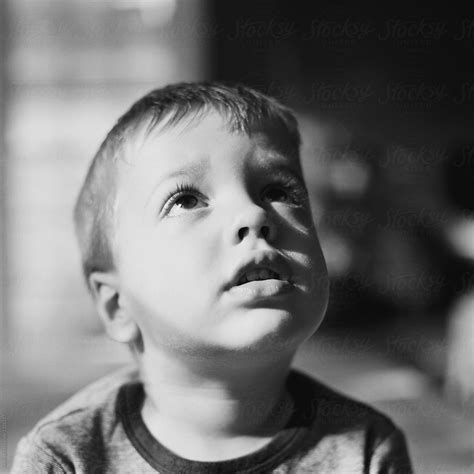 Black And White Close Up Portrait Of A Young Boy Looking Up By
