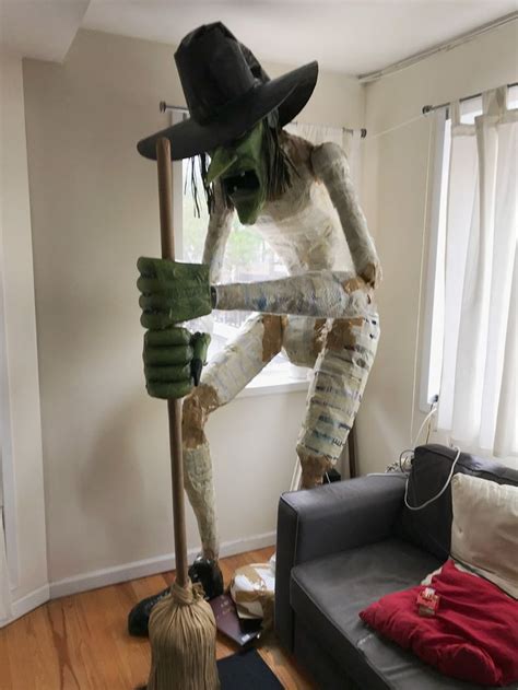 A Living Room Filled With Furniture And A Giant Scarecrow On Top Of A Broom